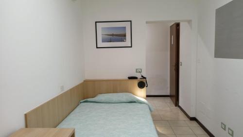 a small bedroom with a bed and a table at Hotel Ariston Imperial in Porto Garibaldi
