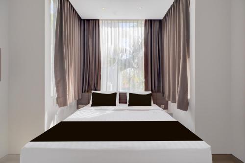 a bedroom with a large bed in front of a window at Palette Signature Hotel in Sanur