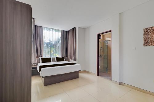 a bedroom with a bed and a window at Palette Signature Hotel in Sanur