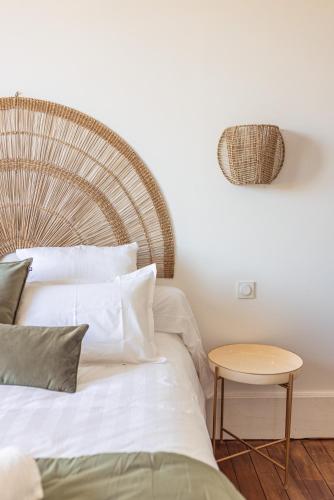 a bedroom with a white bed and a table at Maison Gabrielle in Vals-les-Bains
