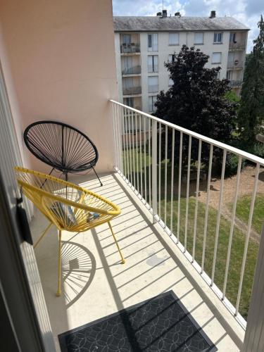 a yellow chair sitting on a balcony at appartement cosy tout équipé avec balcon in Châlette-sur-Loing