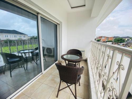 a balcony with chairs and a table on a balcony at PRESKEN WHITE HOUSE in Lagos