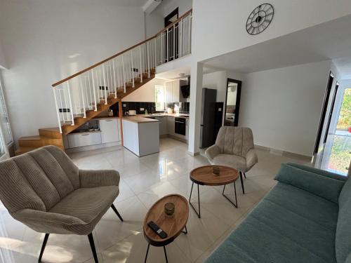 Una sala de estar con un sofá y sillas y una mesa. en Sea Garden House Mandre, en Mandre