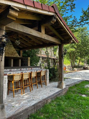 a wooden table and chairs under a pavilion at Hotel Boutique Santuario Kunturi - Adults Only in Llanes