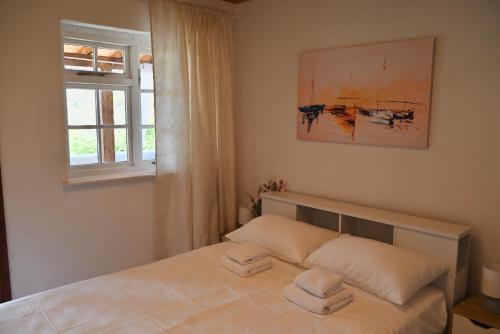 a bedroom with a bed with two towels on it at Rastoni Apartments Skiathos in Troulos