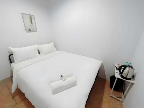 a white bed in a white room with a white bed sidx sidx at XX The Hidden khaosen เดอะ ฮิดเด้น ตรอกข้าวสาร in Bangkok