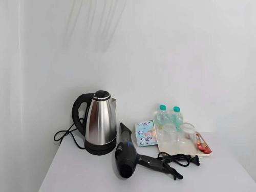 a counter with a coffee maker and bottles of water at XX The Hidden khaosen เดอะ ฮิดเด้น ตรอกข้าวสาร in Bangkok