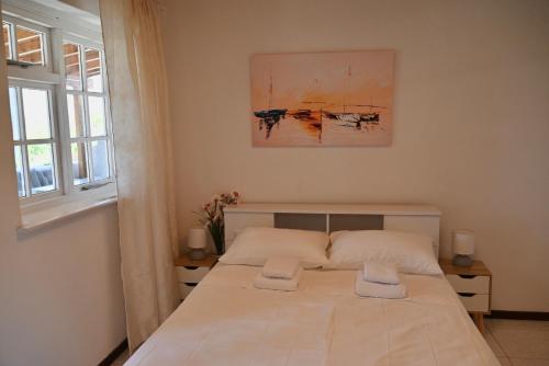 a bedroom with a bed with two towels on it at Rastoni Apartments Skiathos in Troulos