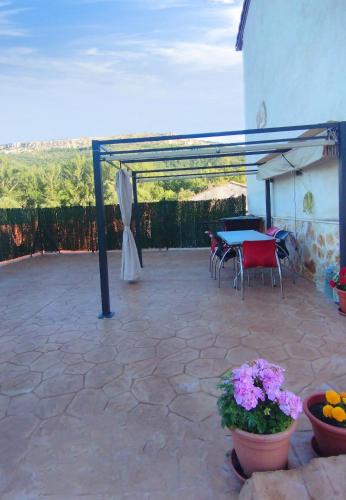 a patio with a table and chairs and flowers at La Mira in Barriosuso
