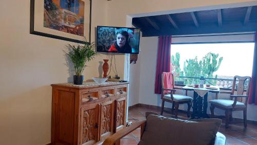 a living room with a tv on top of a wooden cabinet at Rustikale Ferienwohnung mit Balkon und Meerblick in Icod de los Vinos