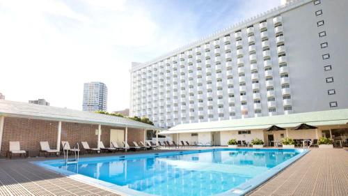a hotel swimming pool in front of a building at The Prince Sakura Tower Tokyo, Autograph Collection in Tokyo