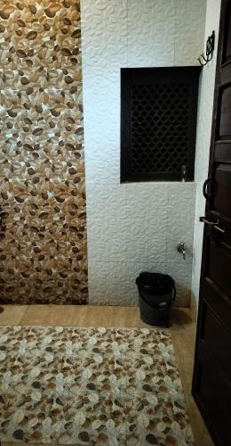 a bathroom with a stone wall and a toilet at Castle View Haveli in Jodhpur