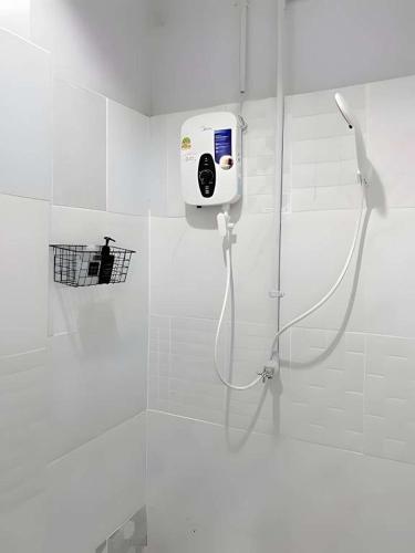 a shower in a white bathroom with a shower at XX The Hidden khaosen เดอะ ฮิดเด้น ตรอกข้าวสาร in Bangkok