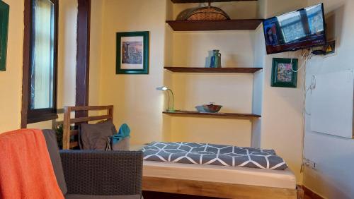 Habitación con cama y TV en la pared. en Kleines Einzelzimmer mit Meerblick, en El Guincho