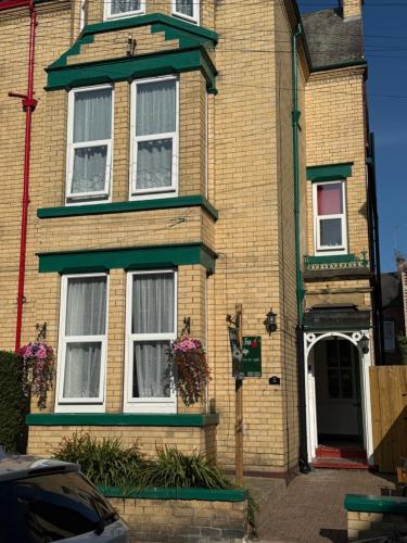 a yellow brick house with white windows and a door at Apple Tree Lodge in Bridlington