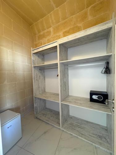 a bathroom with wooden shelves with a radio at Fiftyfour West Boutique Living in Għarb