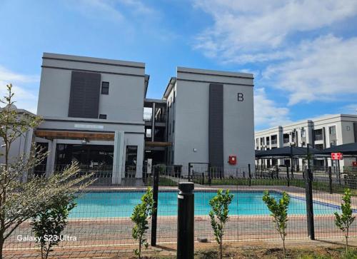 a building with a swimming pool in front of it at Schumie Apartments in Gaborone