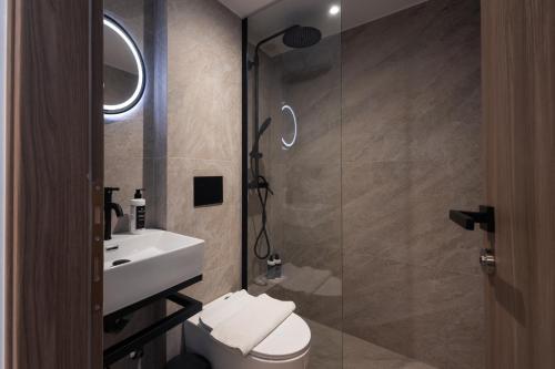 a bathroom with a sink and a toilet and a shower at Frati Villas Beachfront in Perivolos