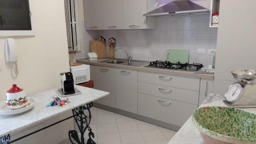 a kitchen with white cabinets and a sink at Villa Marilu Fontane Bianche - SiciliaVacanza in Fontane Bianche