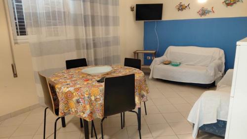 a dining room with a table and a couch at Villa Marilu Fontane Bianche - SiciliaVacanza in Fontane Bianche