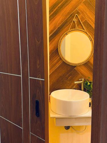 a bathroom with a sink and a mirror on the wall at Khế Homestay in Can Tho