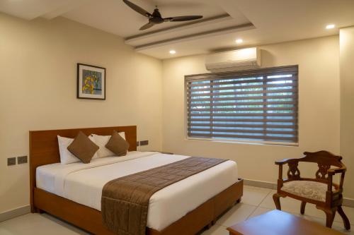a bedroom with a bed and a window with a fan at Villa De 1945 in Mahe