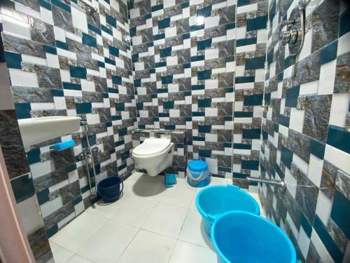 a bathroom with a toilet and a sink and two blue at Hotel O Heritage Inn in Mehsāna