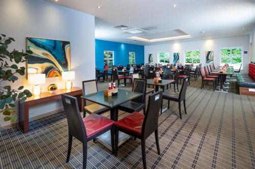 a dining room with tables and chairs in a restaurant at Holiday Inn Express Taunton East by IHG in Taunton