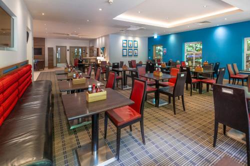 a restaurant with tables and chairs and blue walls at Holiday Inn Express Taunton East by IHG in Taunton