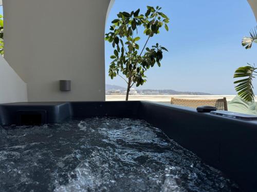 a hot tub in a room with a window at Kastro Suites in Fira