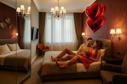 a man and woman sitting on a bed in a hotel room at HIGHLINE DOWNTOWN ApartHotel OLDTOWN UNIRII SQUARE in Bucharest