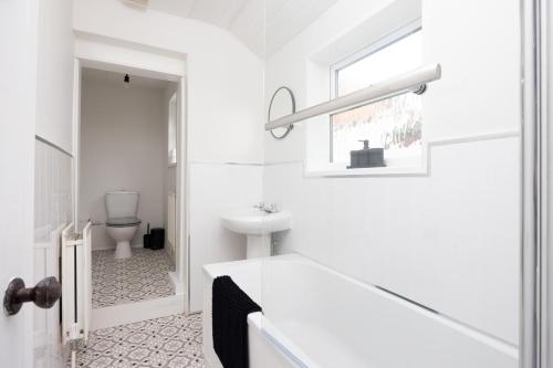 ein weißes Badezimmer mit Waschbecken und Toilette in der Unterkunft Charming 3-BR Home Near Historic Town Centre in Bishop Auckland
