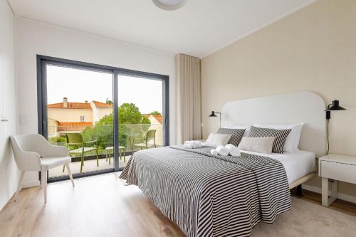 Un dormitorio blanco con una cama y una ventana grande. en Paraiso da Foz - BY SCH, en Foz do Arelho