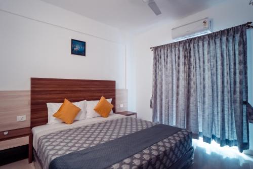 une chambre d'hôtel avec un lit et une fenêtre dans l'établissement Ocean Whisper Goa, à Jāmb