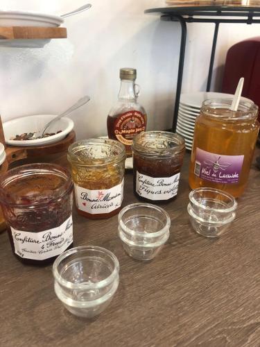 a table with jars of jam and bowls of food at Best Western Hôtel Le Sud in Manosque