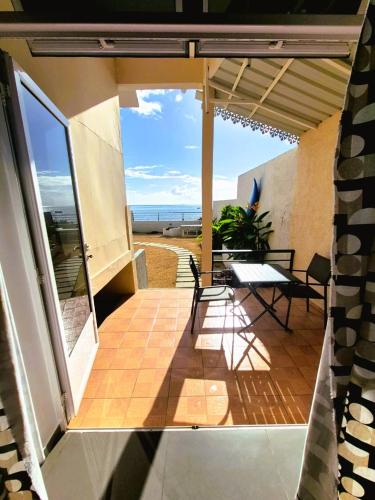 a patio with a table and chairs on a balcony at Baywatch Apartment in La Gaulette