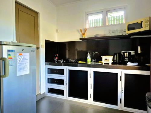 a kitchen with white cabinets and black counter tops at Baywatch Apartment in La Gaulette