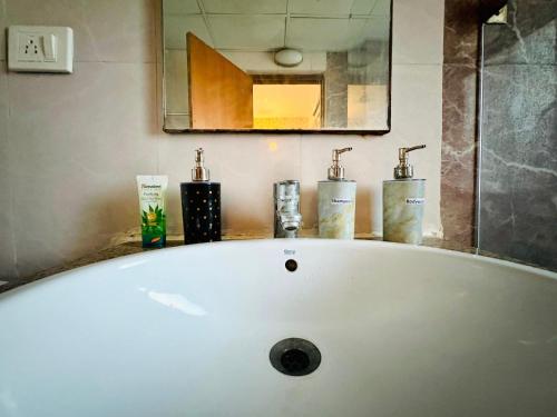 a white bath tub with two faucets in a bathroom at Dream Vibes the Cosy Stay in Noida