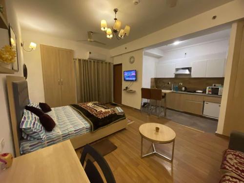 a living room with a bed and a kitchen at Dream Vibes the Cosy Stay in Noida