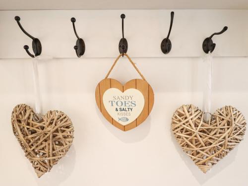 three wooden hearts hanging on a wall at Sandy Toes in Mablethorpe