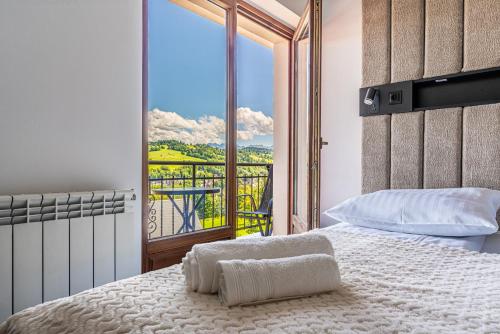 Un dormitorio con una cama con vista a un balcón. en Home Tatra, en Biały Dunajec