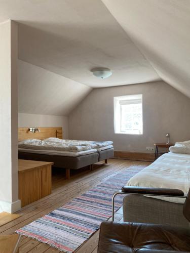 a attic room with two beds and a rug at Mallas Stenstugu B&B in Visby