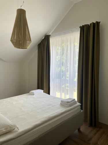 ein Schlafzimmer mit einem Bett mit einem großen Fenster in der Unterkunft MiMi Palanga - Self Check-in in Palanga