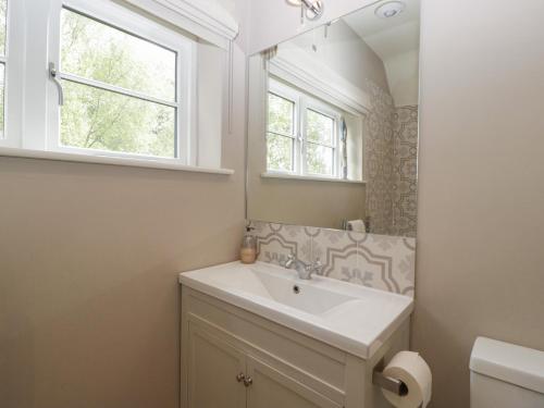 a bathroom with a sink and a mirror at St Mary's House in Chipping Norton