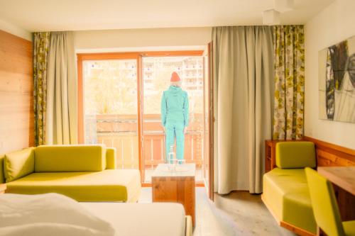 un soggiorno con un manichino davanti a una finestra di Hotel Glemmtalerhof a Saalbach Hinterglemm