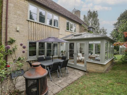 a conservatory with a table and chairs and an umbrella at St Mary's House in Chipping Norton