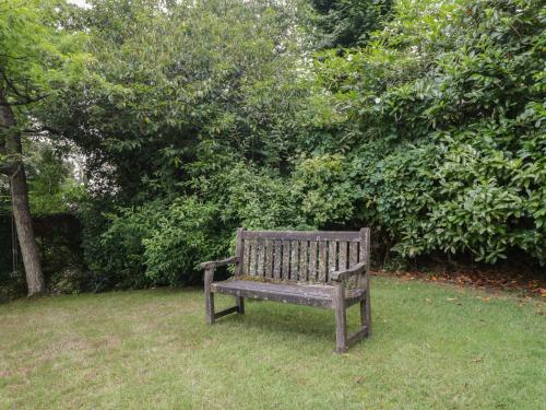a wooden bench sitting in the grass in a park at St Mary's House in Chipping Norton