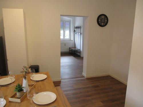 a dining room with a table and a clock on the wall at Parsberger City Rooms 104 in Parsberg