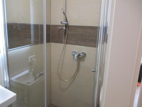 a shower with a glass door next to a sink at Parsberger City Rooms 104 in Parsberg