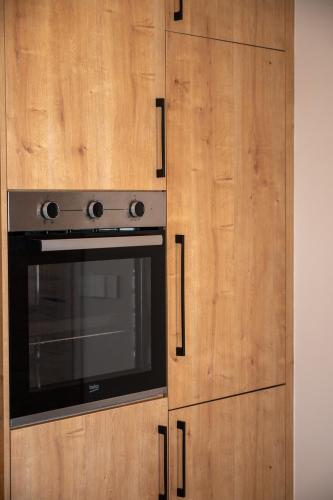 a kitchen with a stove and wooden cabinets at Kooba Villas in Gázion